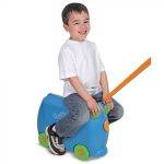 Παιδί κάθεται πάνω σε μπλε βαλίτσα Trunki Terrance SK7 με ροδάκια